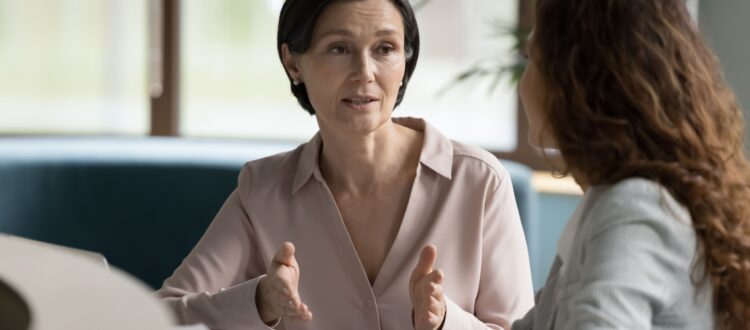 A woman meets with her financial planner in a corporate office.