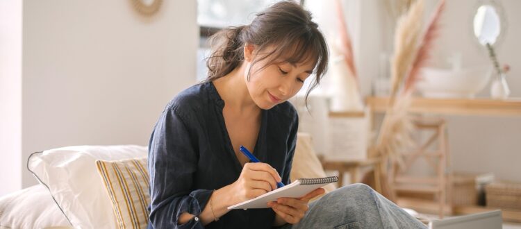 Focused woman making notes in a notebook