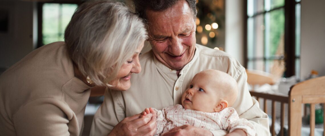 Grandparents holding a baby, playing with her and soothing her