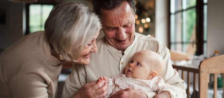 Grandparents holding a baby, playing with her and soothing her