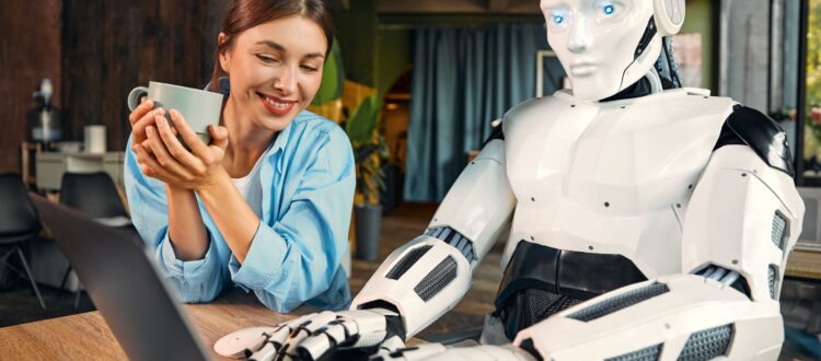 Young woman with a cup of coffee watching while a robot works at a laptop