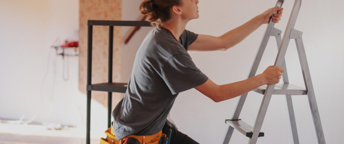 Young woman climbing a ladder in her new home