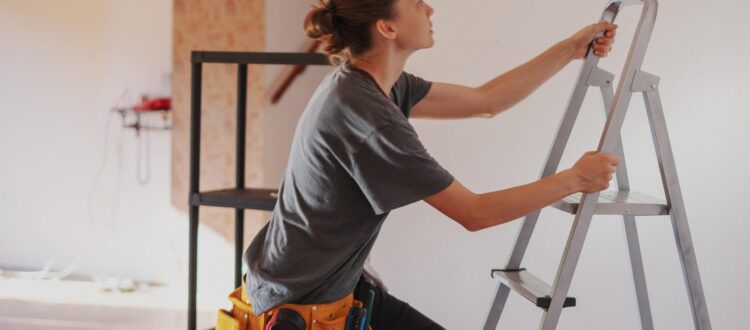 Young woman climbing a ladder in her new home