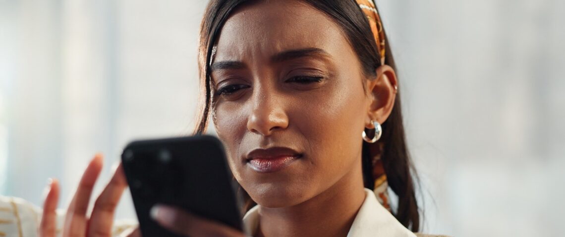 A woman frowning at her phone