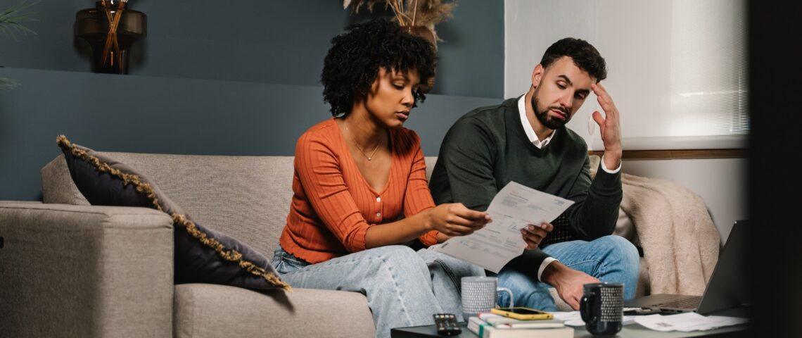 Stressed couple looking worried while going through finances