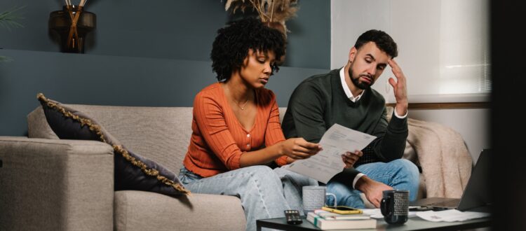 Stressed couple looking worried while going through finances